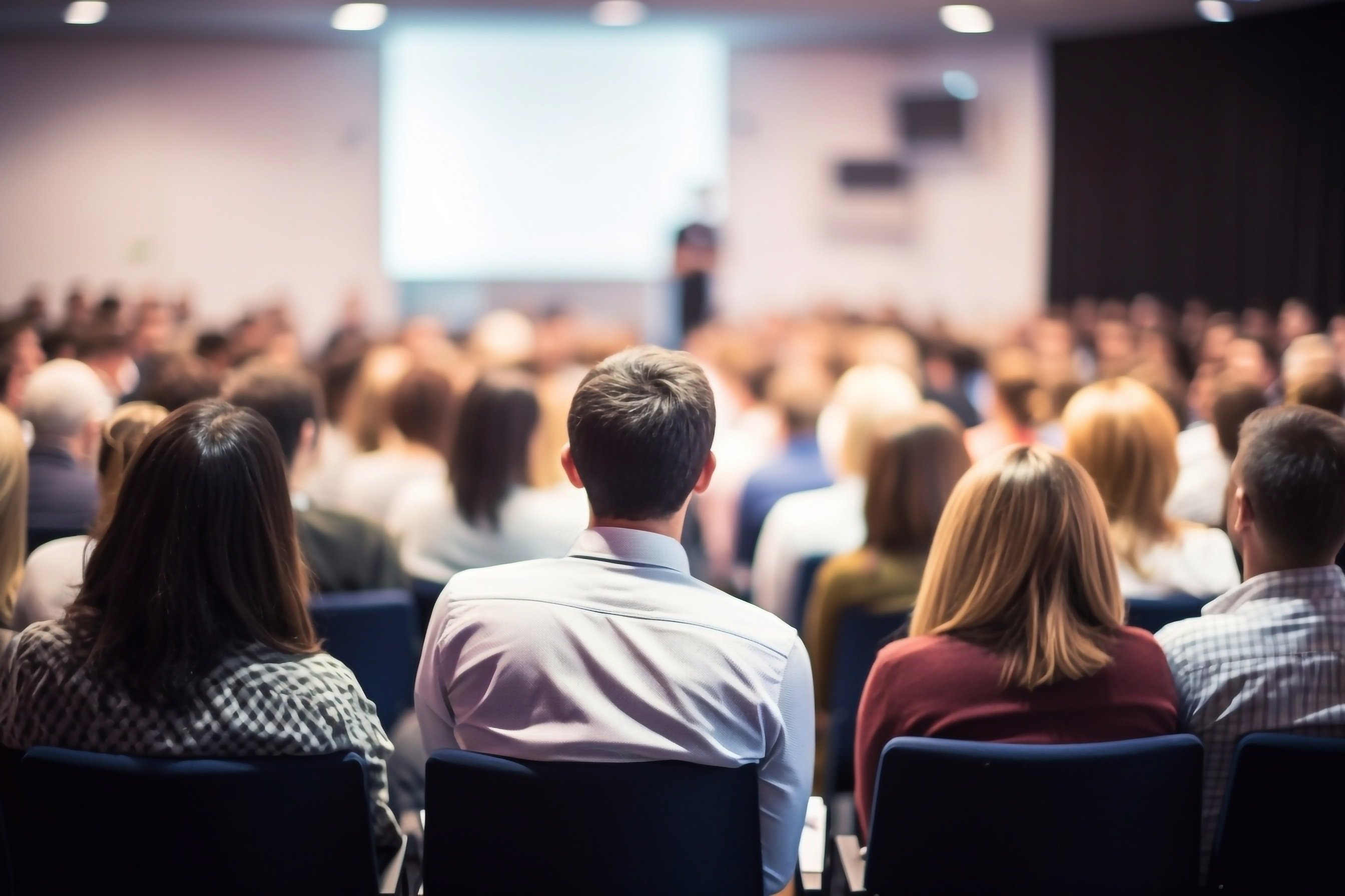 Large professional convening, audience facing a speaker