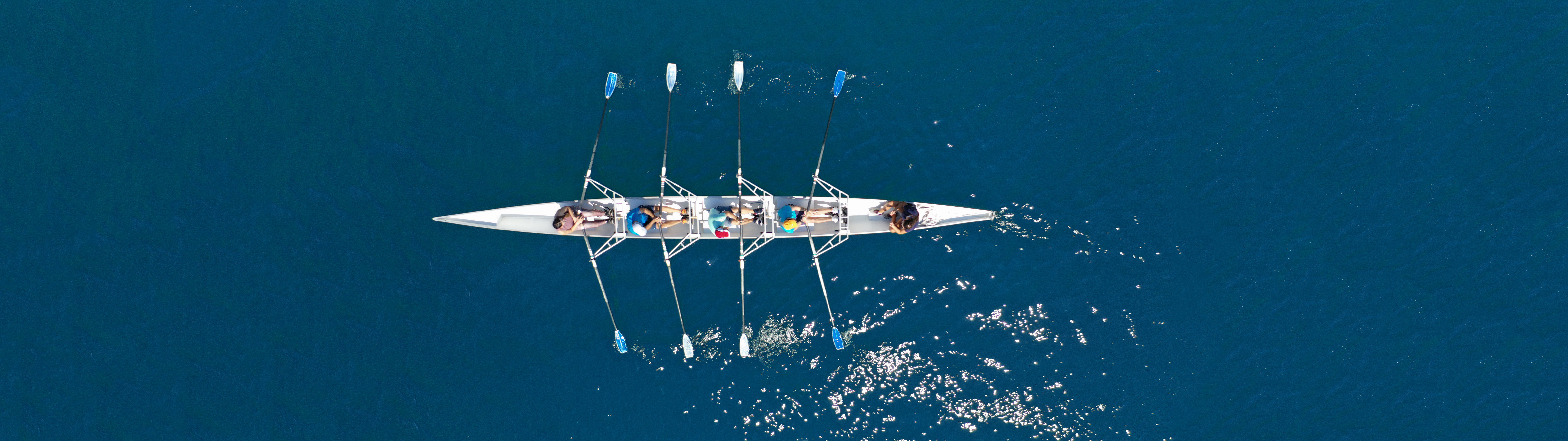 Aerial view of a rowing team moving in perfect sync