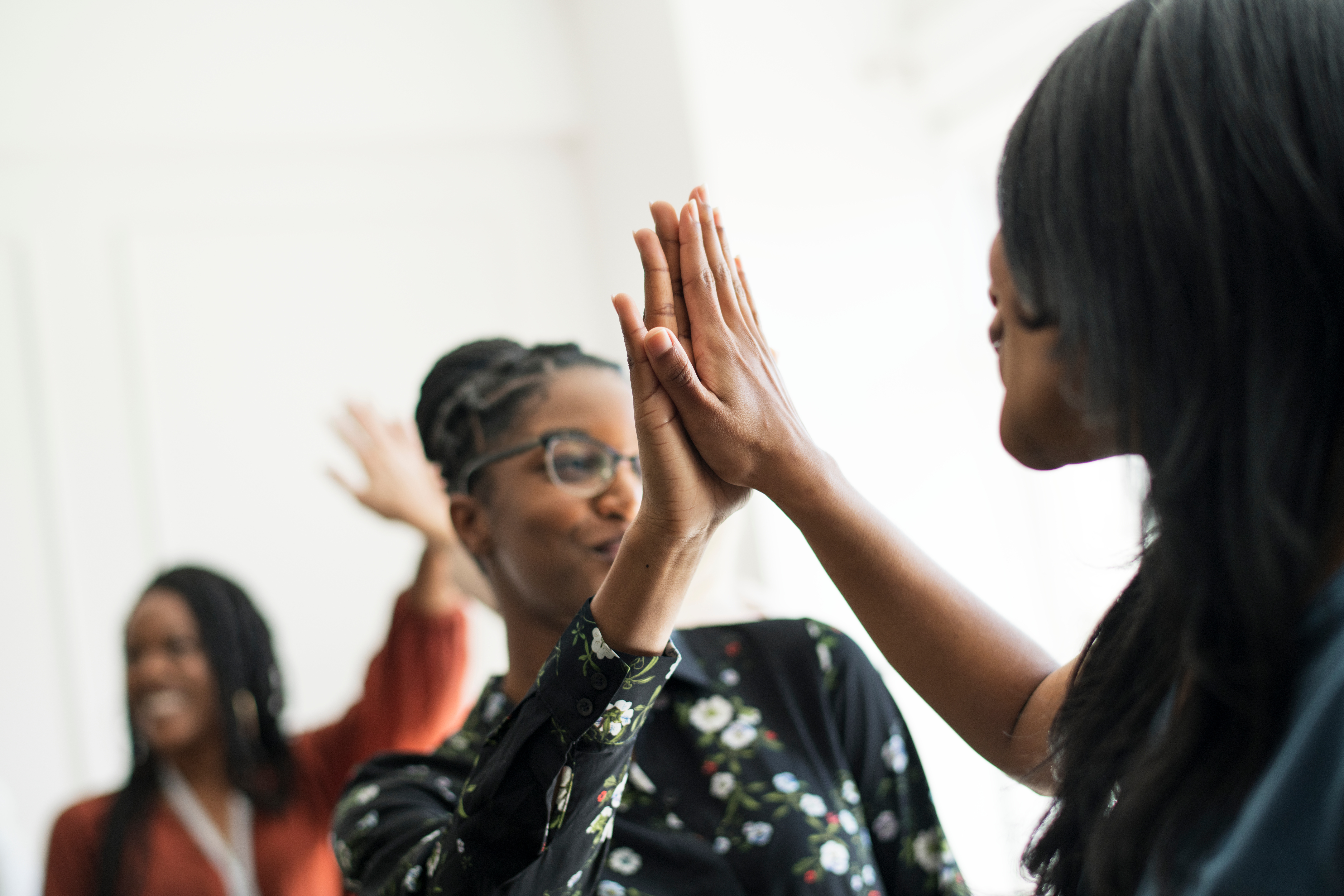 Women celebrating and high-fiving in a workshop setting